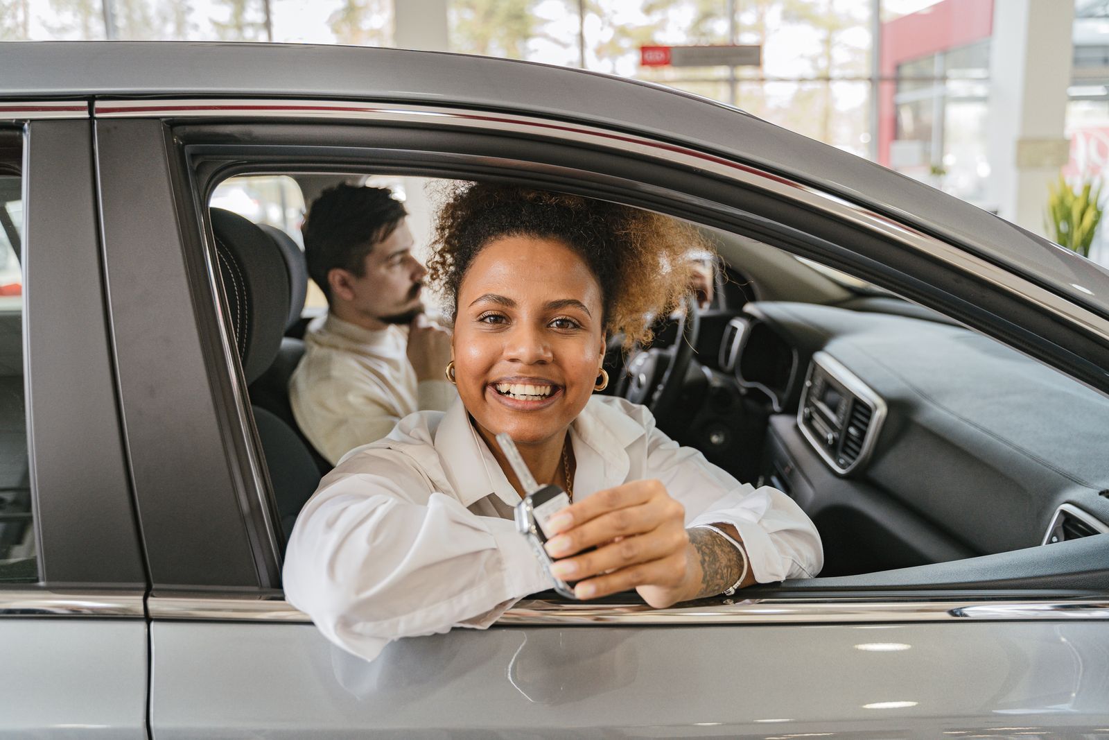 Customer in a new car inside a dealership showroom