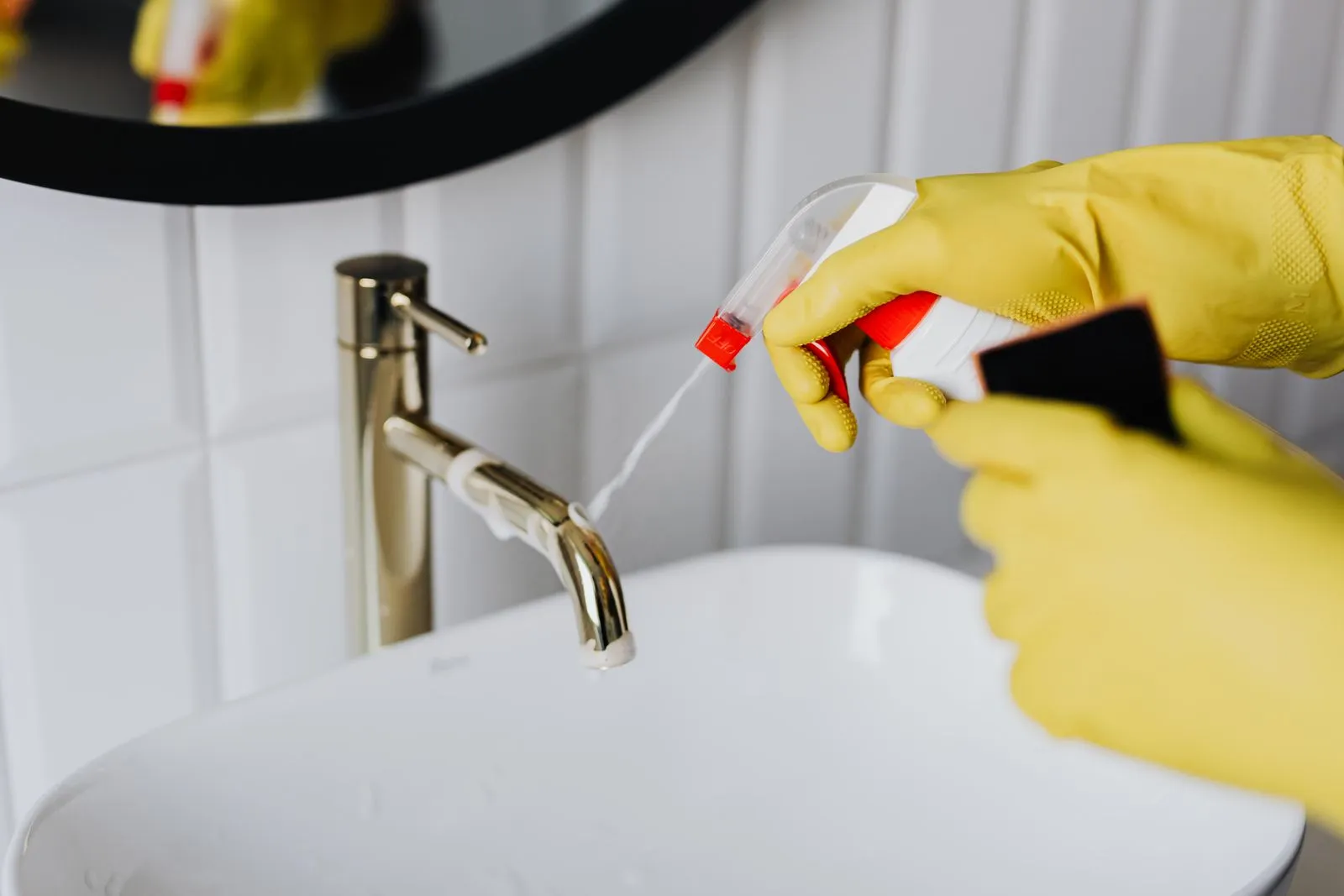Detail cleaning of a bathroom faucet with cleaning spray