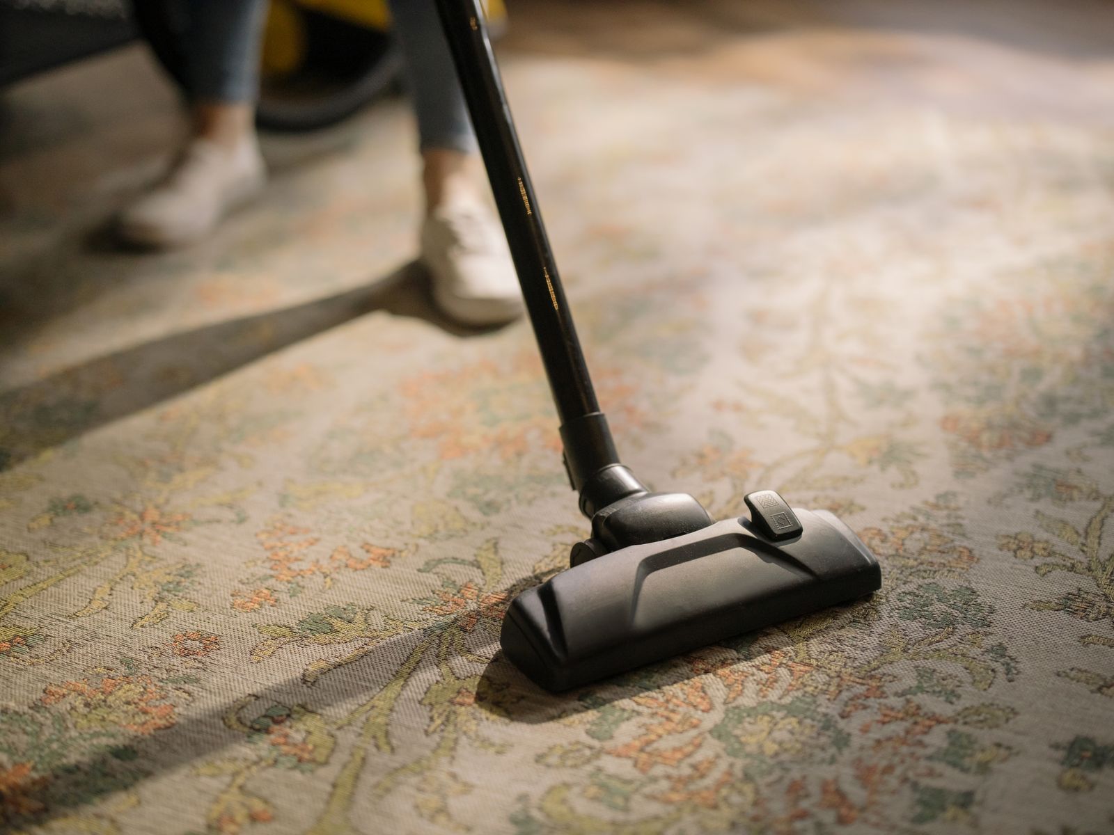 Close-up of vacuuming carpet — part of an office cleaning checklist