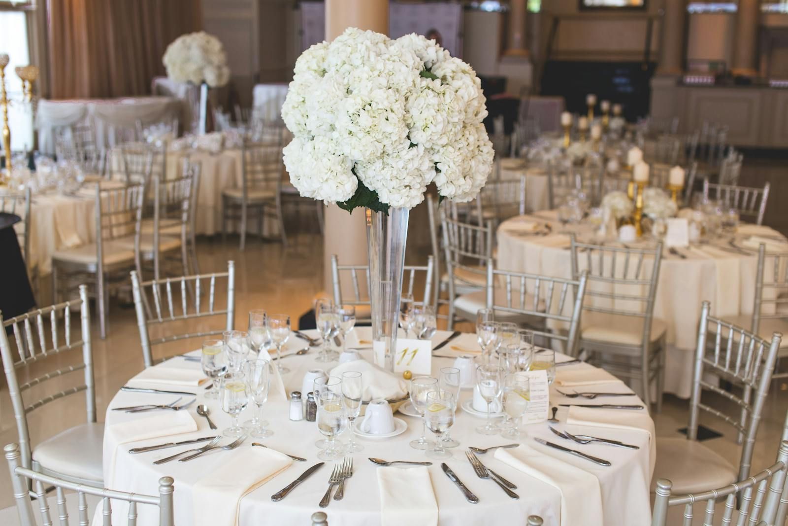 Elegant banquet hall set with white linens and centerpieces