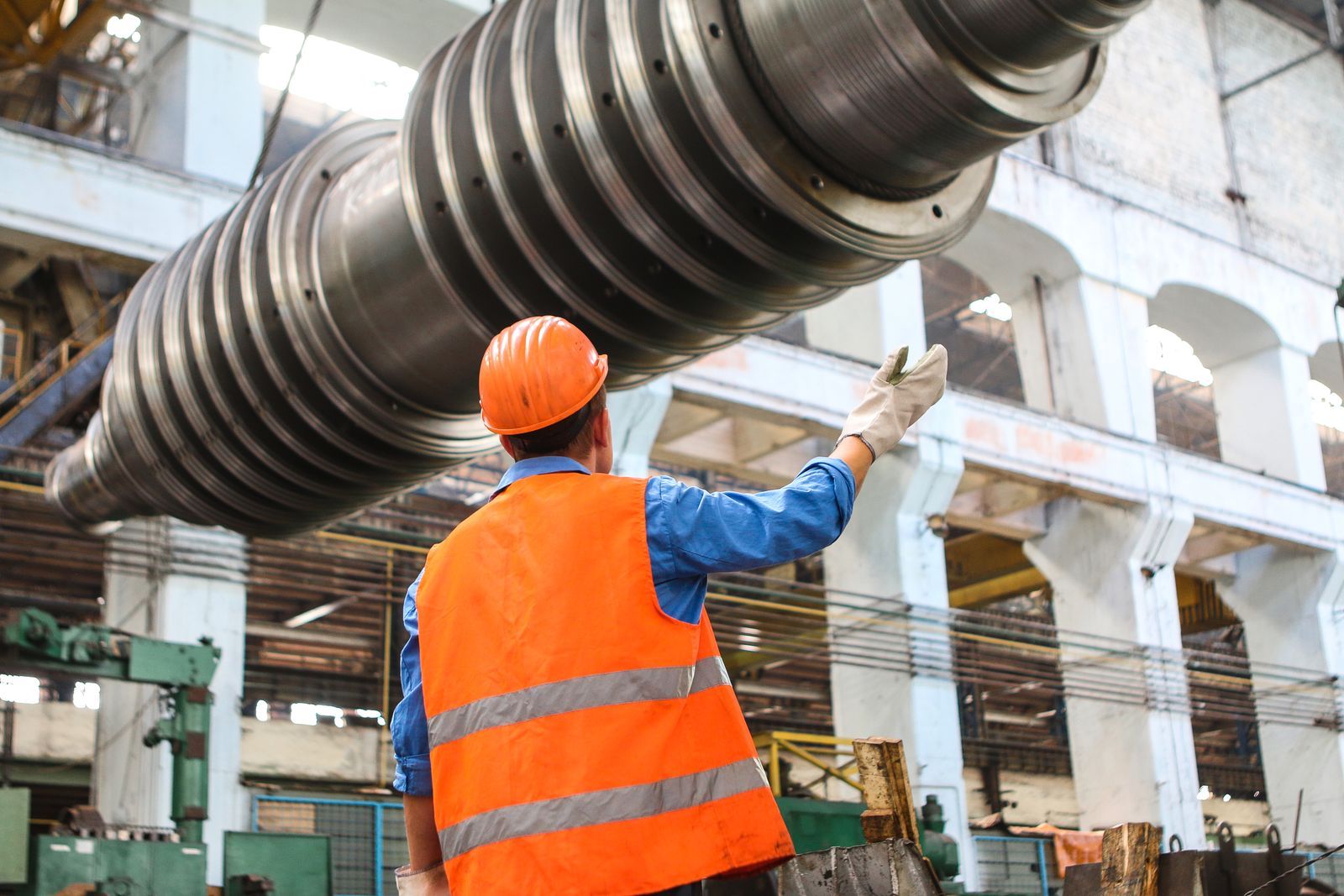 Worker on a manufacturing facility floor with heavy machinery