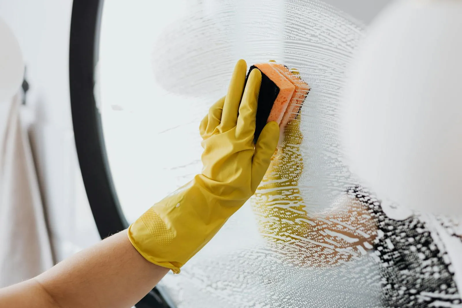 Gloved hand polishing a mirror to a streak-free shine