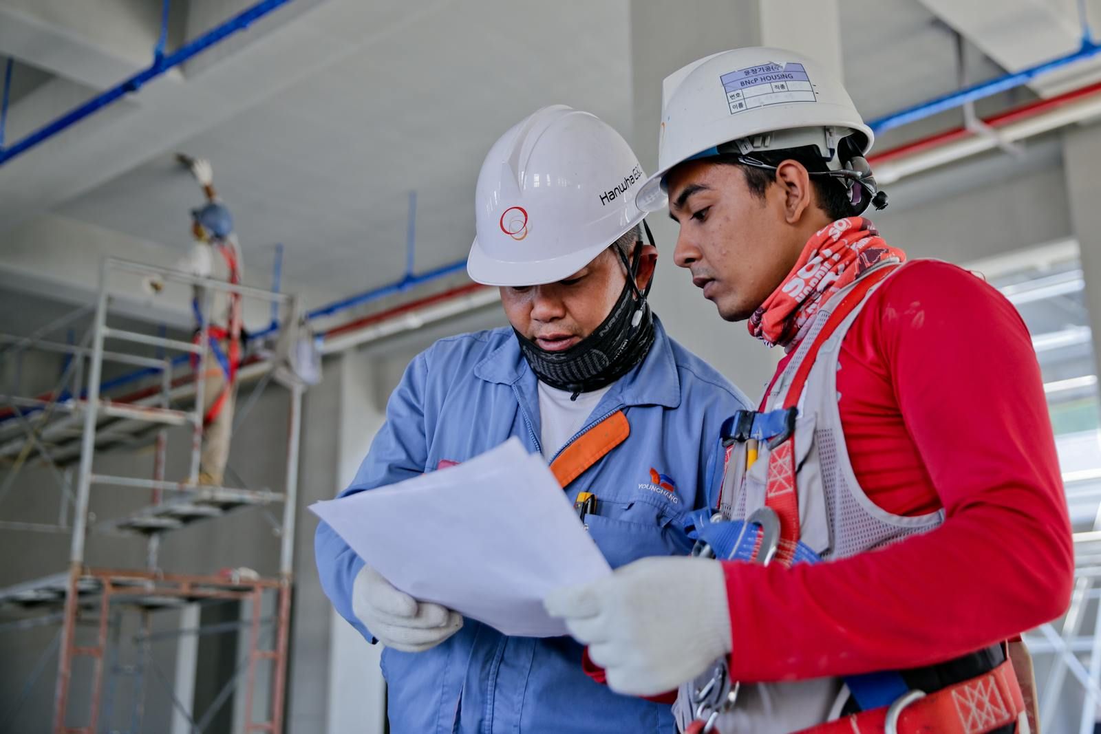 Construction supervisors reviewing plans inside an unfinished building