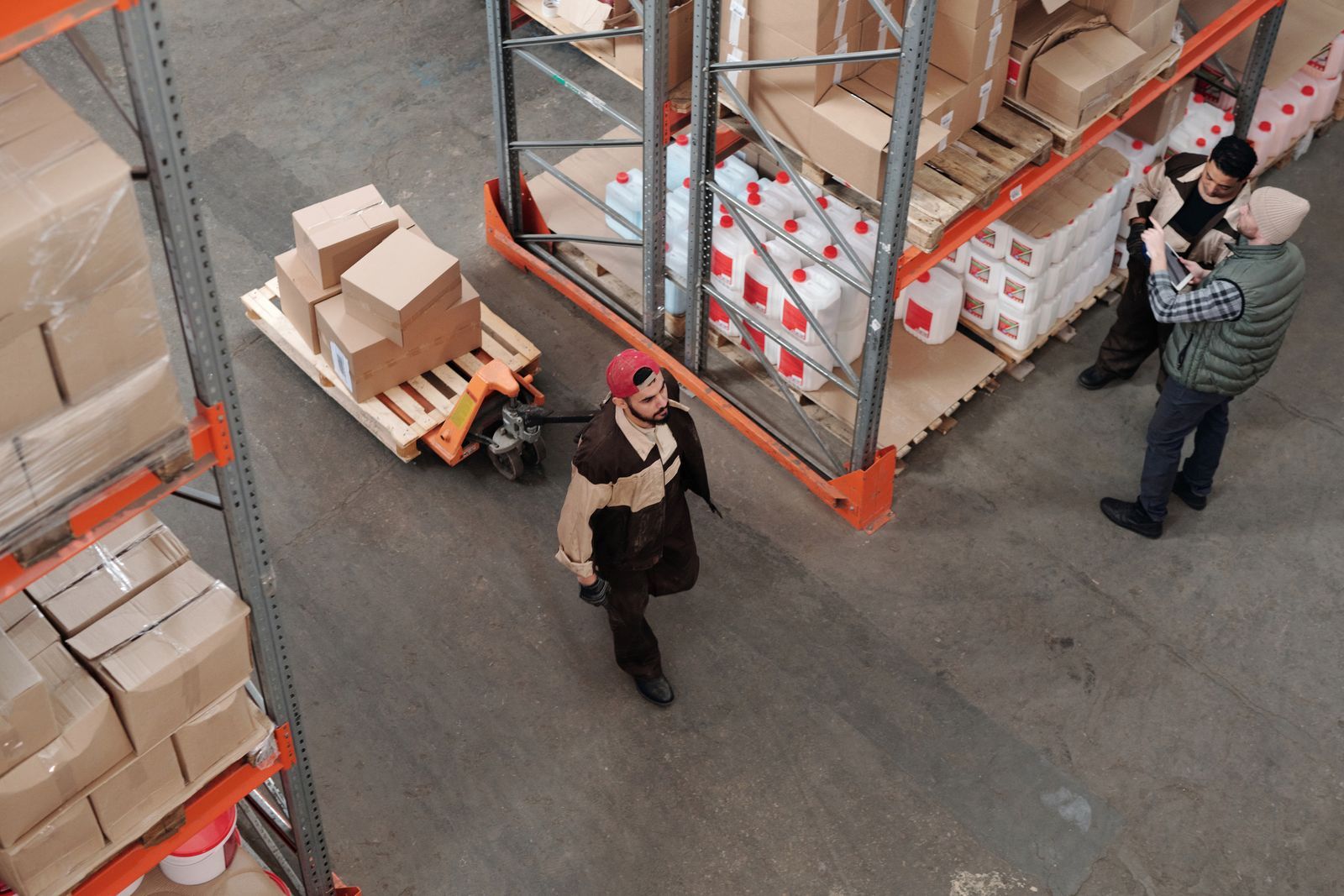 Warehouse racking aisles with workers moving stock