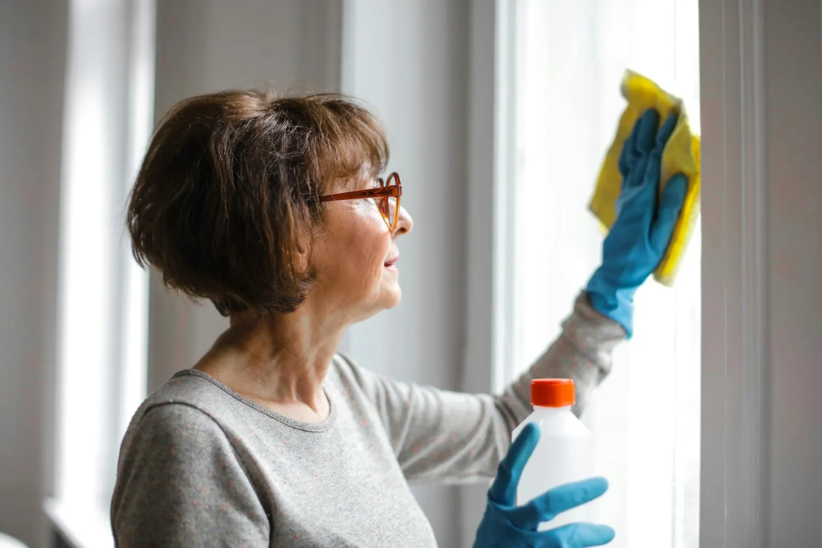 Window cleaning with spray and cloth in a historic home
